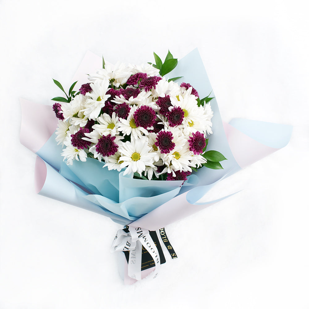 Mother's Day Spring Daisy Bouquet, white and purple daisies gathered with ruscus in a floral wrap and tied with a designer ribbon, Flower Gifts from Blooms New Jersey - Same Day New Jersey Delivery.
