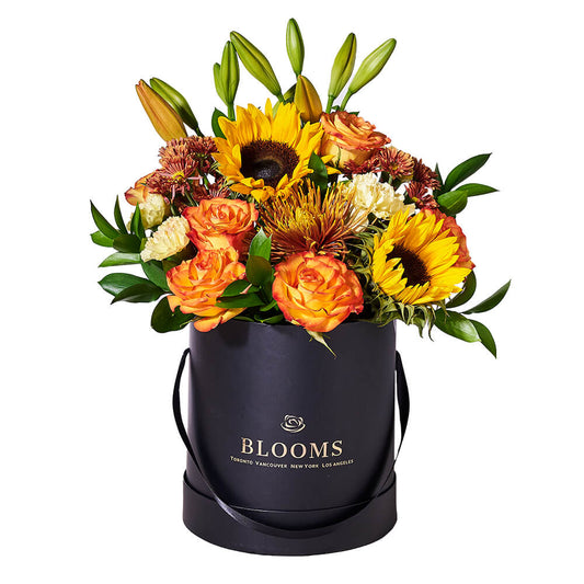Fall Flower Arrangement, orange lilies, sunflowers, bronze daisies, roses, yellow carnations, a spider chrysanthemum, and greens displayed in a tall, round, black hat box, Flower Gifts from Blooms New Jersey - Same Day New Jersey Delivery.