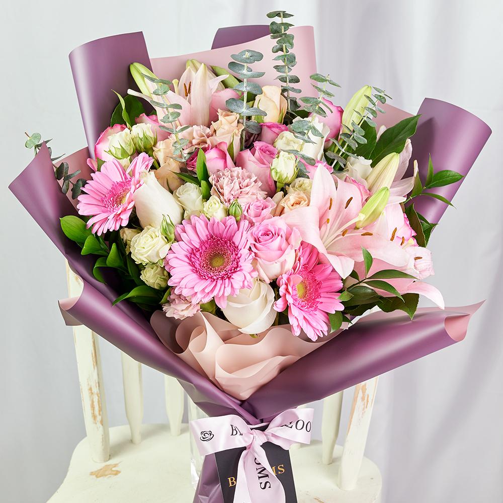 Pastel Pink Variety Bouquet, pastel roses, spray roses, lilies, gerbera, carnations, and eucalyptus in a floral wrap and tied with designer ribbon, Mixed Floral Gifts from Blooms New Jersey - Same Day New Jersey Delivery.