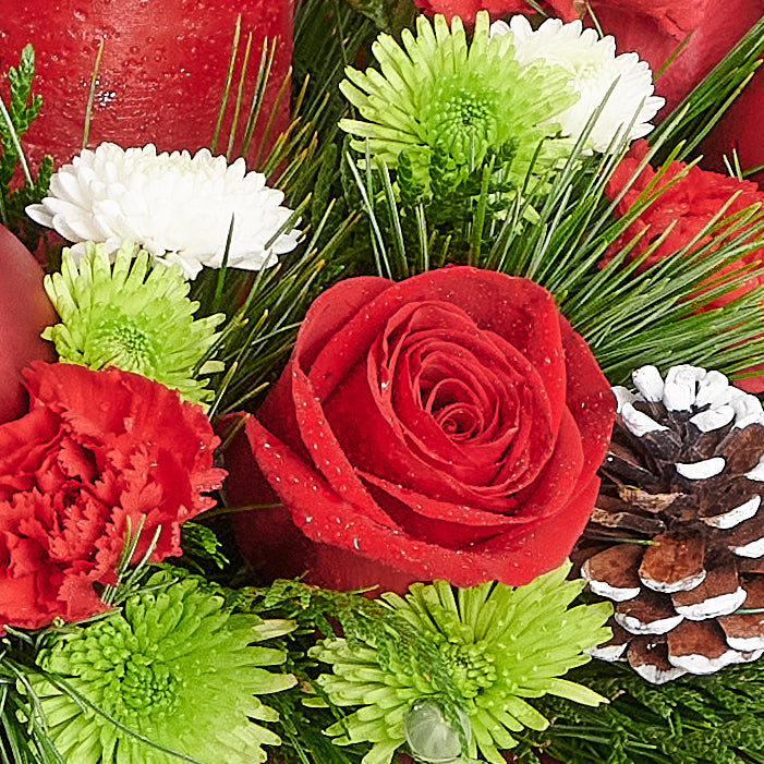 Christmas Cheer Floral Centerpiece, pine, cedar, roses, chrysanthemums, daisies, pine cones, a candle, a Christmas decoration, glass ornaments, and ribbon in a dark wicker basket, Holiday Gifts from Blooms New Jersey - Same Day New Jersey Delivery.